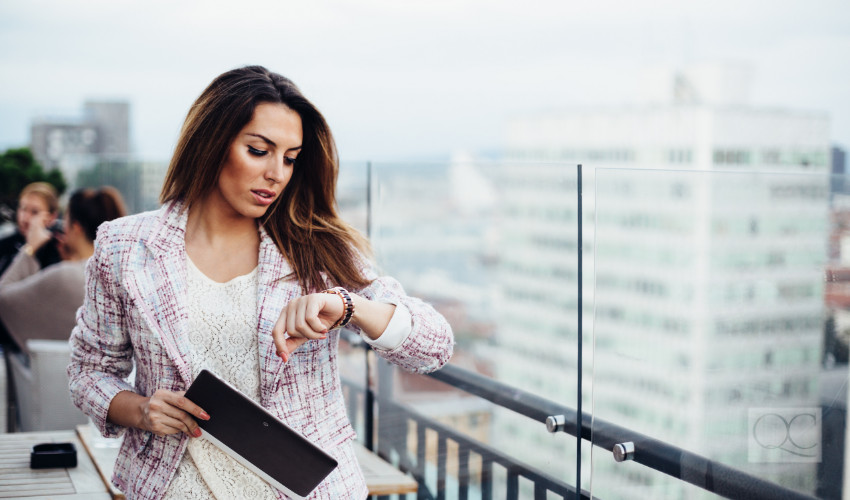 business woman checking clock to keep organized and on time