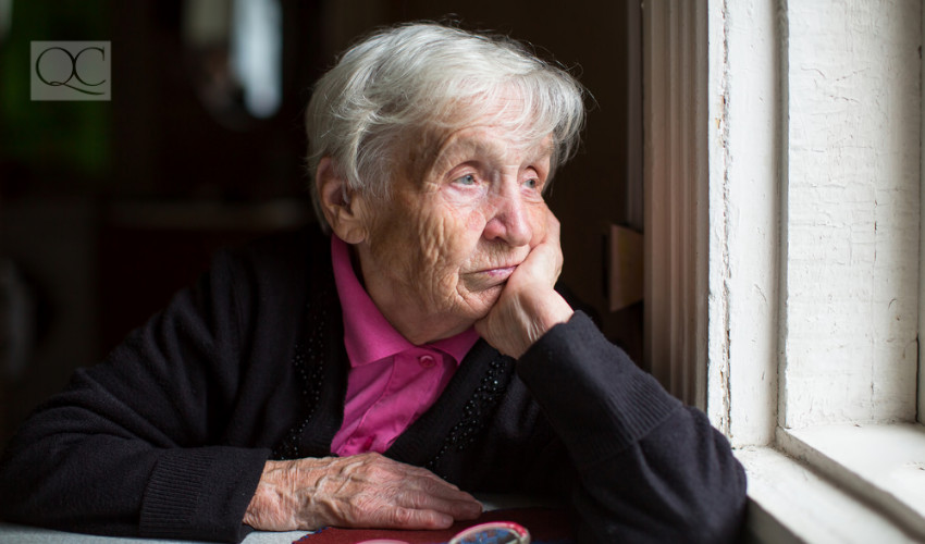 old lady looking out of window sad and pensive