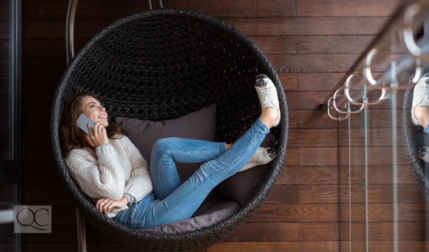 happy woman in unique chair interior decor on phone