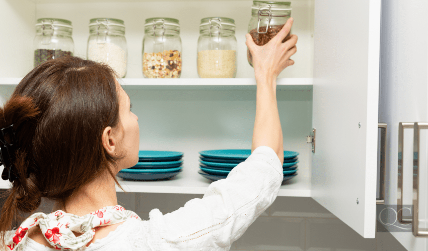 Women stacking item in storage hutch. Smart kitchen organization concept