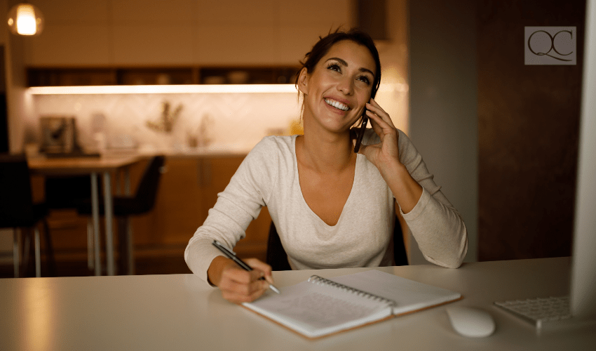 woman talking on cell phone and taking notes