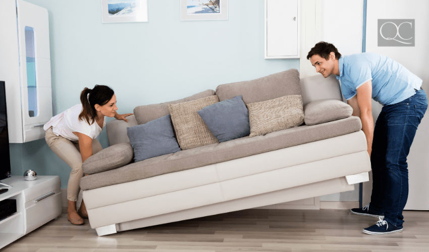 couple moving couch in living room