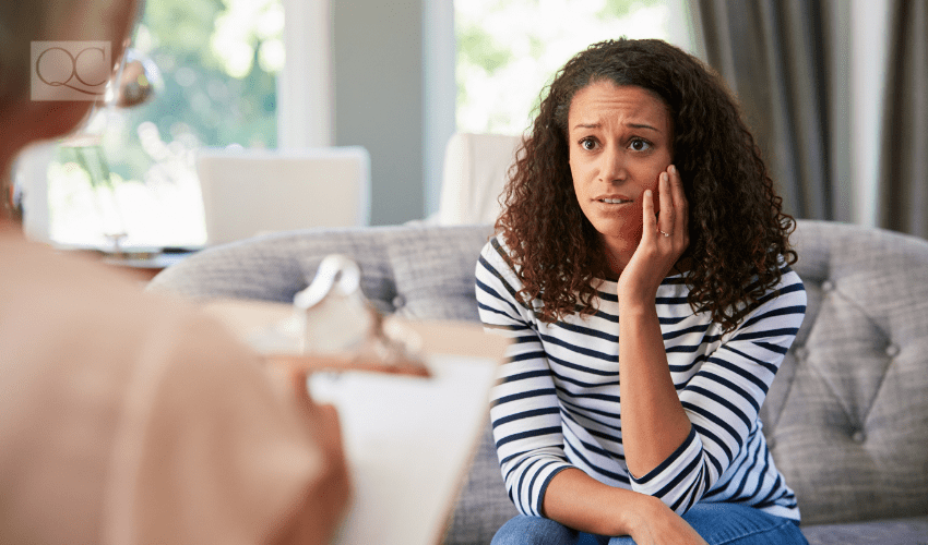 confused client listening to professional on couch at home