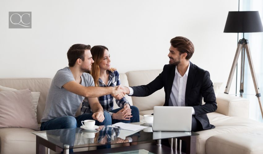 Young couple, family at meeting with realtor, interior designer, decorator, landlord making deal. Husband handshaking with man in suit. Concept of meeting with client, customer