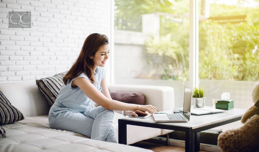 Happy adult woman working with laptop in living room